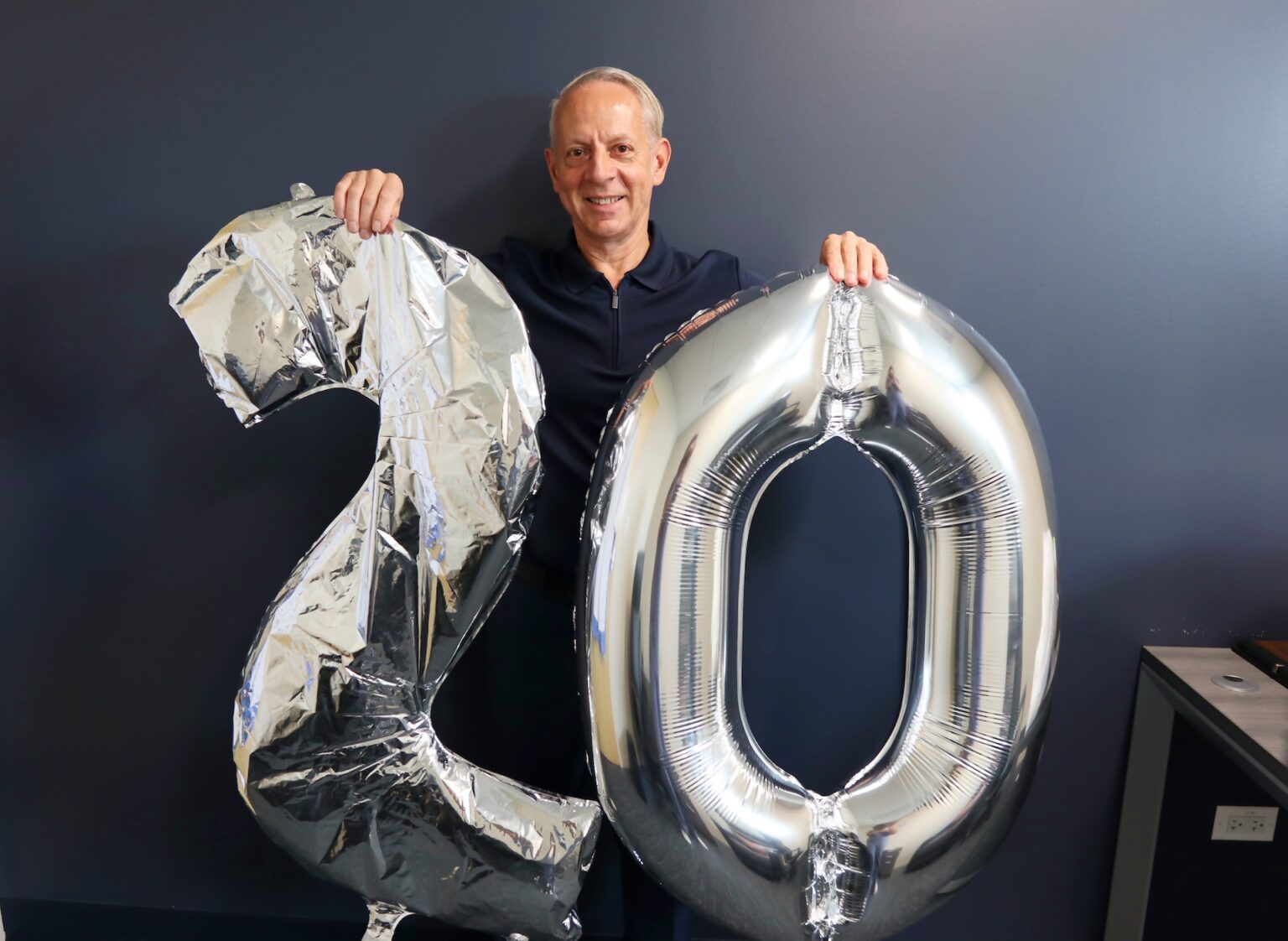 Man holding up balloon number 20